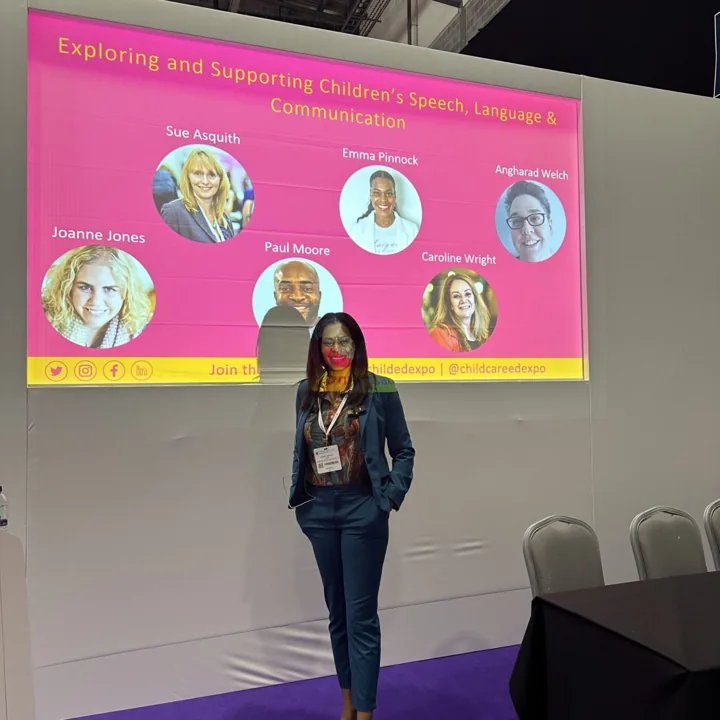 Emma standing in front of a speaker presentation screen.