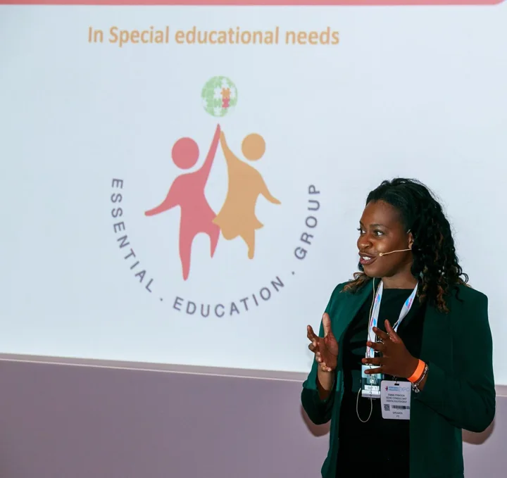 Emma presenting beside an Essential Education Group slide.