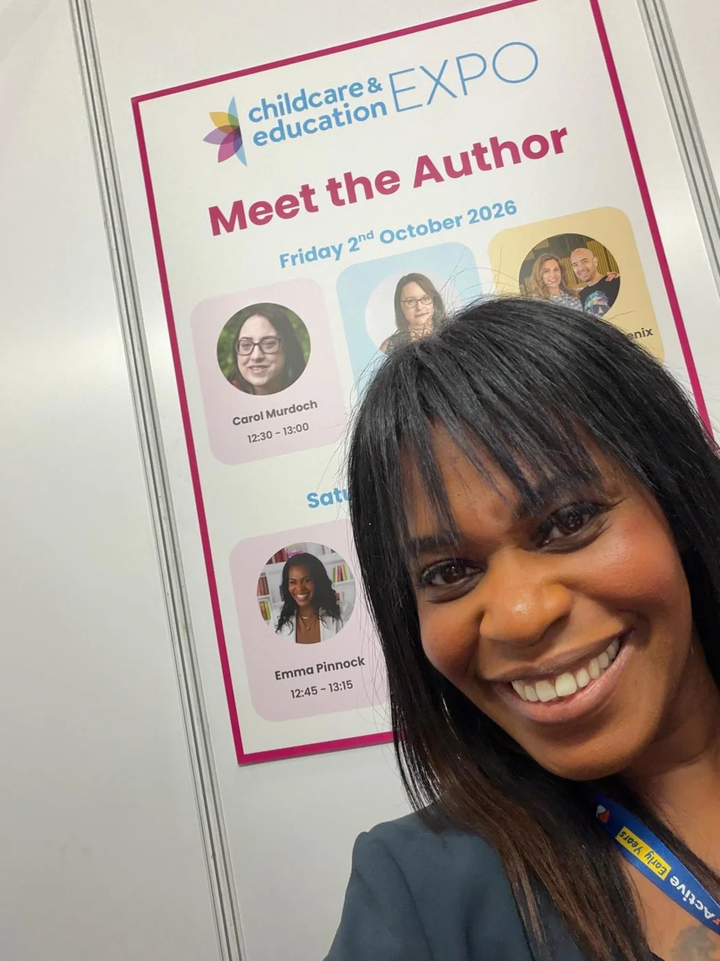 Emma smiling beside a Meet the Author event display.