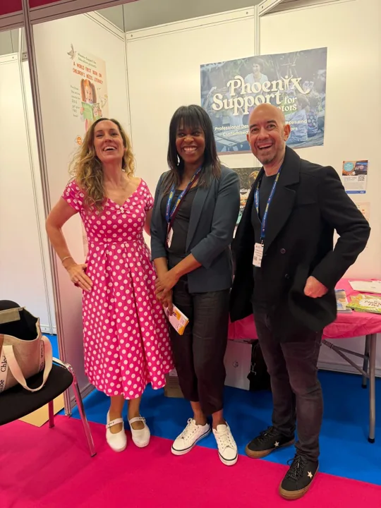 Emma standing with two adults at a Phoenix Support for Educators stand.