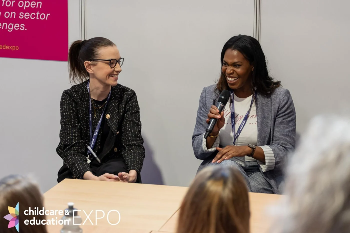 Emma holding a microphone in conversation with another panel participant.
