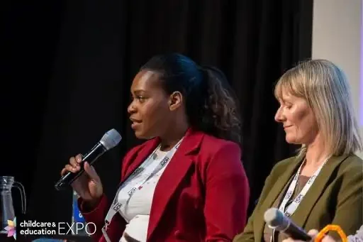 Emma speaking beside another participant on a panel.