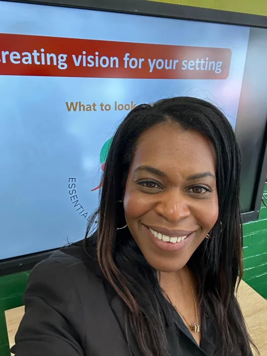 Emma smiling in front of a presentation screen.